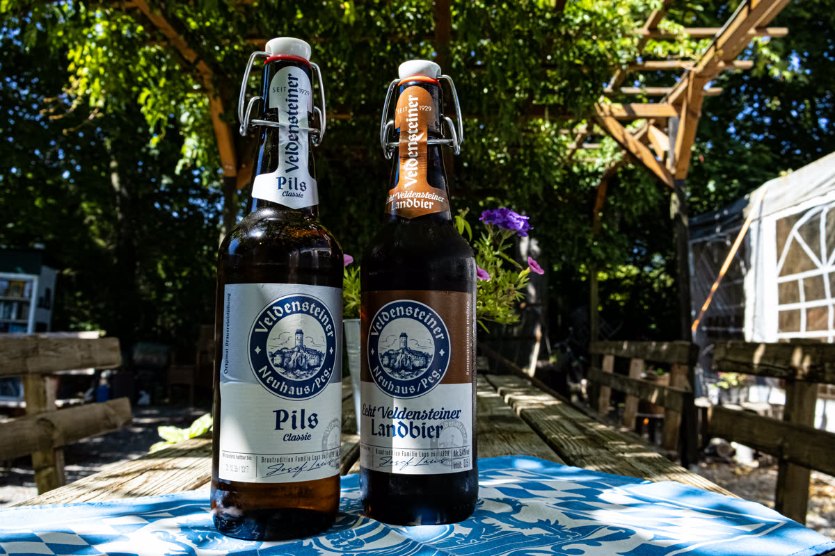 Zwei Veldensteiner Bierflaschen auf einem Tisch im Biergarten