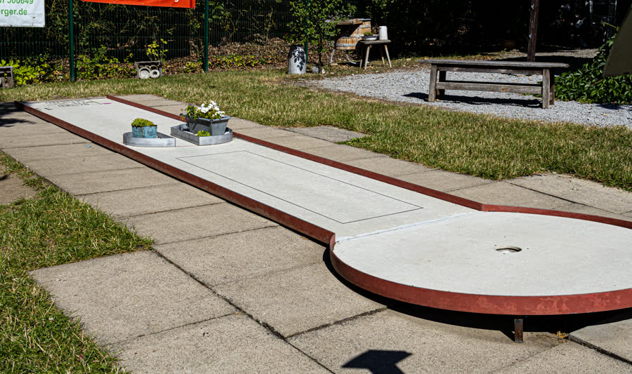 Lange Minigolfbahn mit rotem Rand in der Sonne