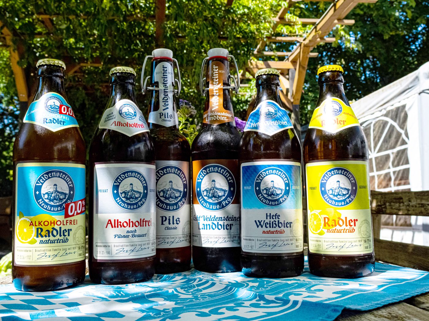 Sechs Veldensteiner Bierflaschen auf blau-weißem Tischläufer