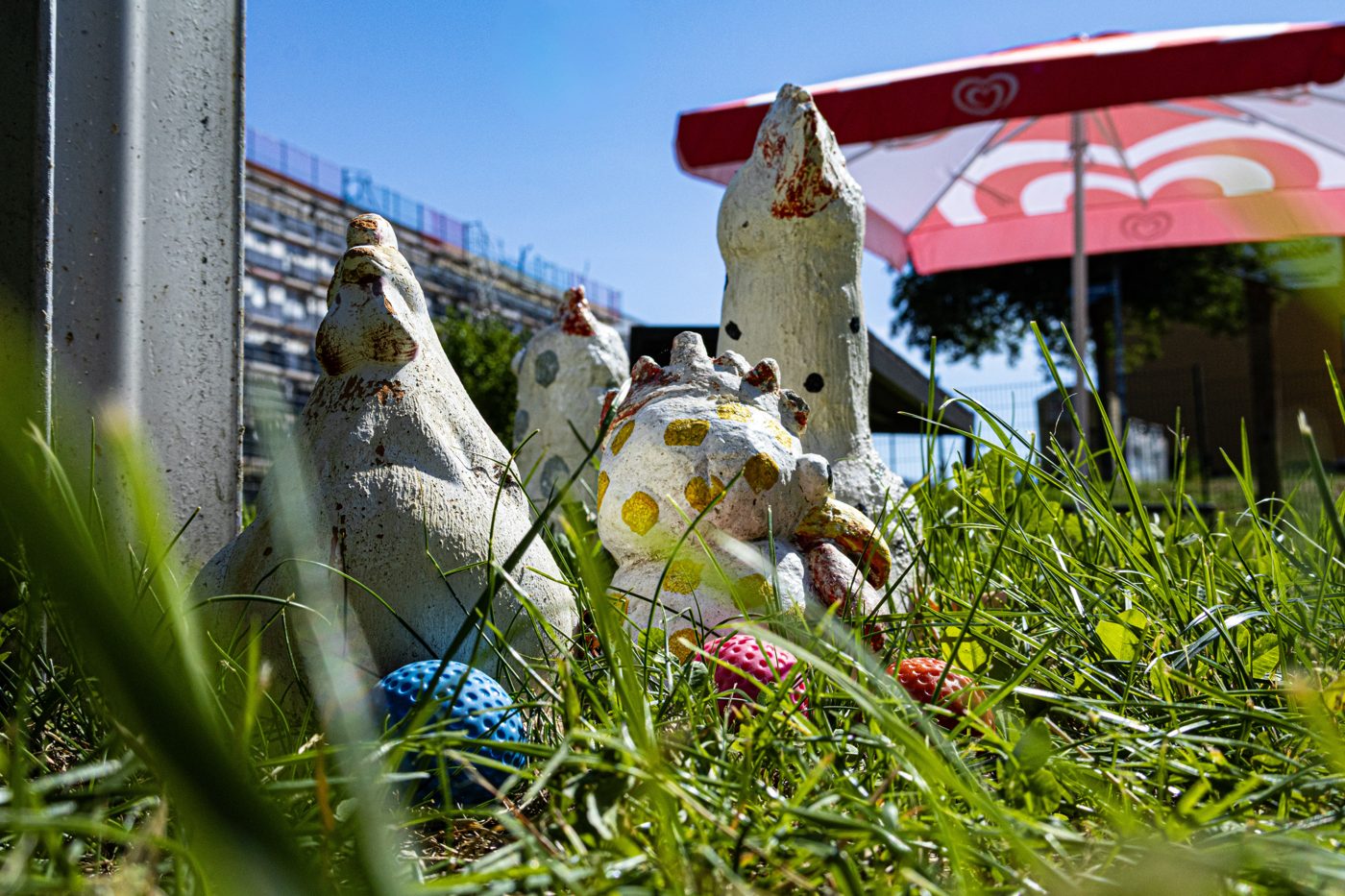 Zwei Spielfiguren im Gras neben einem blauen Minigolfball