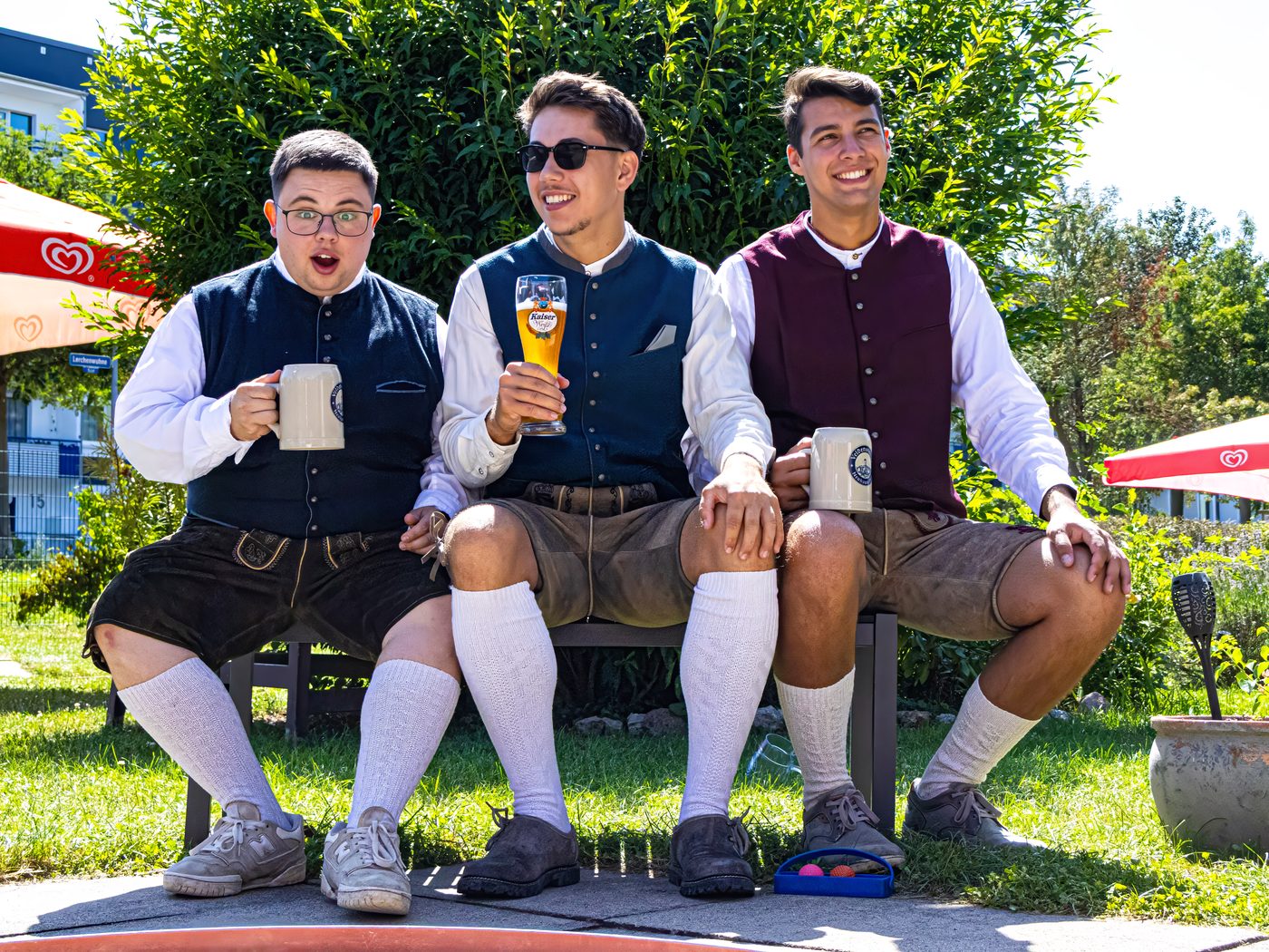 Gäste mit Bier auf der Bank im Biergarten