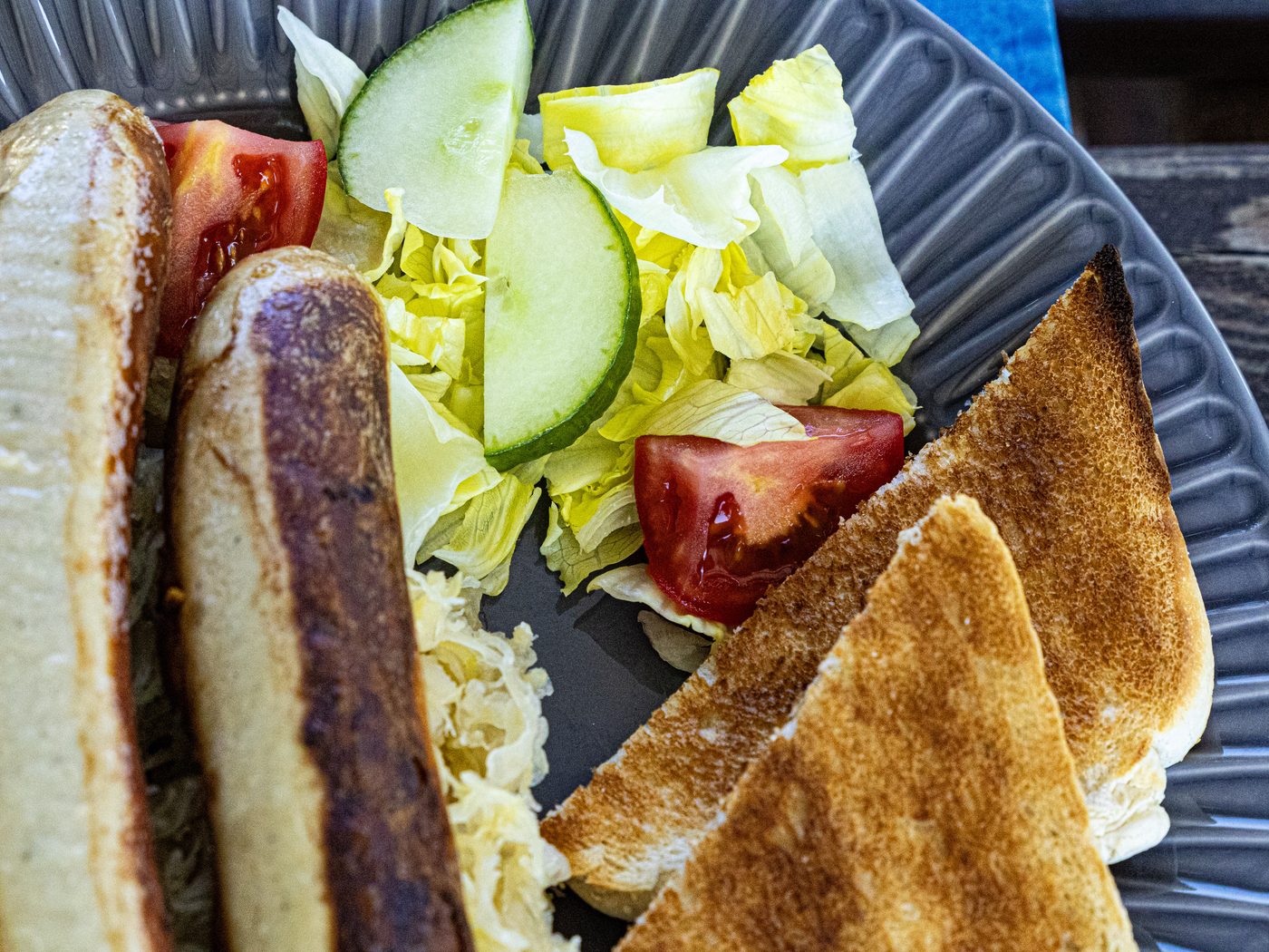 Teller mit Würstl, Brot und Salatgarnitur
