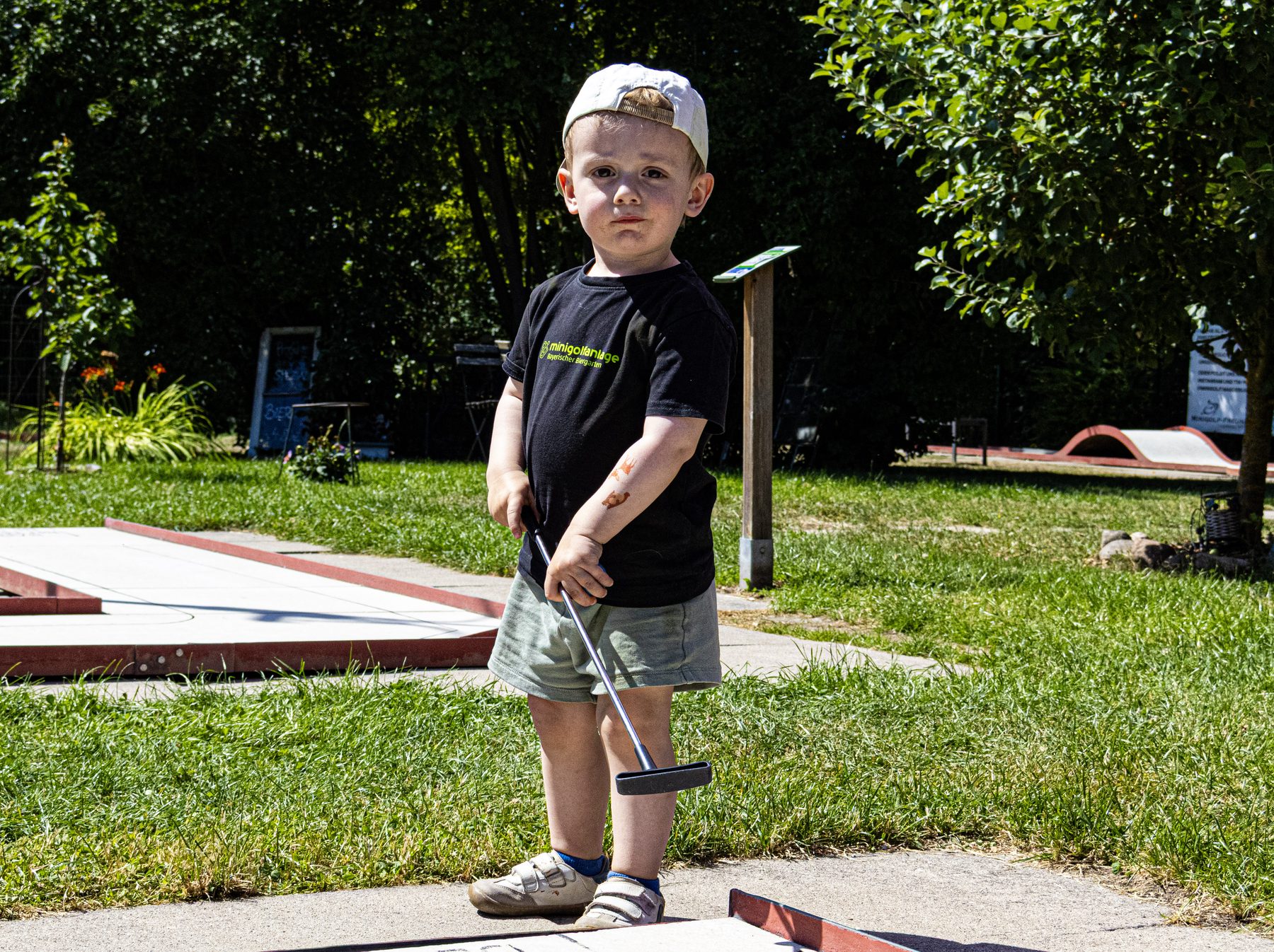 Kind mit Minigolfschlaeger auf der Anlage in Magdeburg